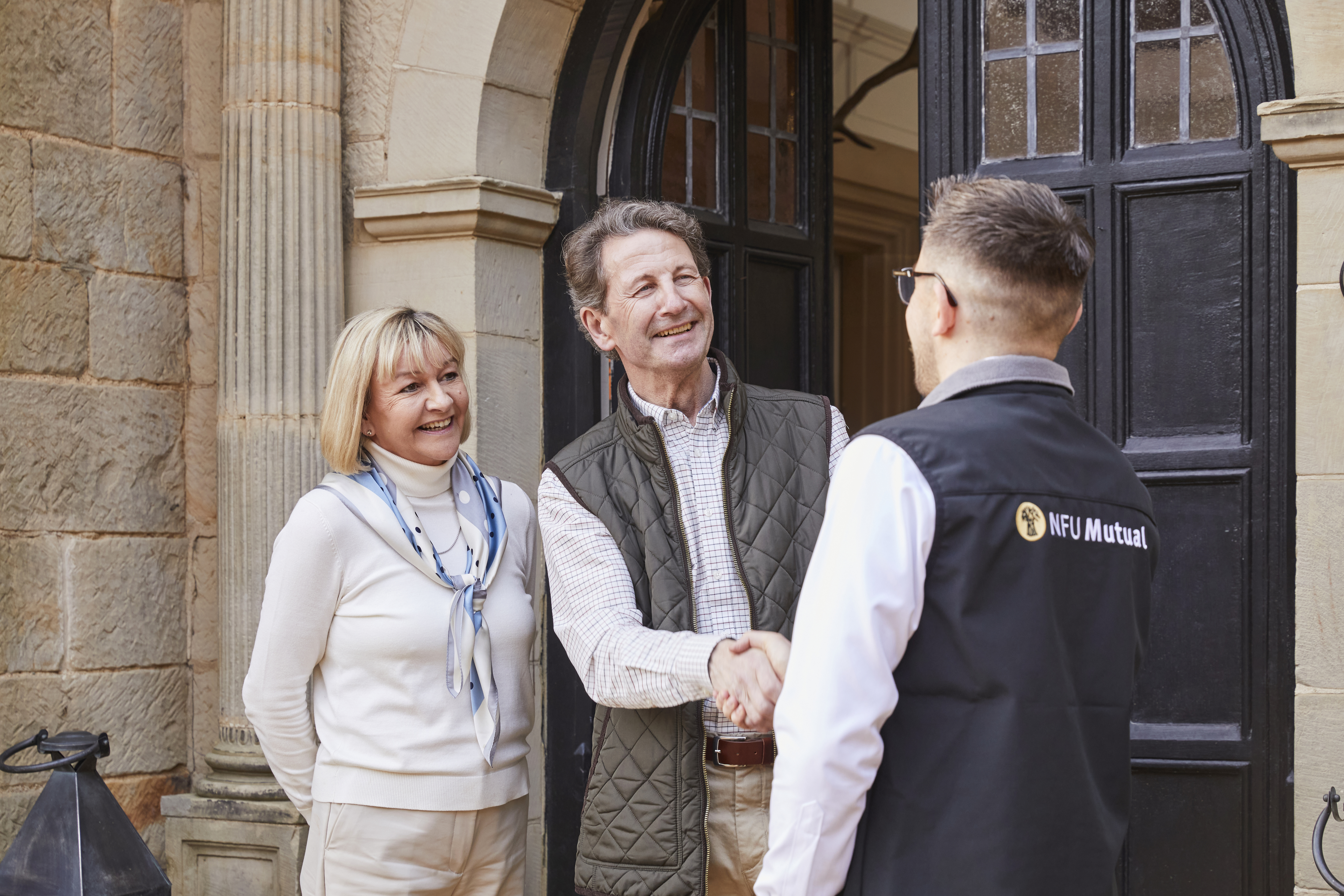 Couple speaking to and shaking hands with an NFU Mutual Agent
