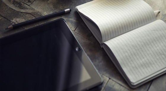 Ipad on table with notebook and pen