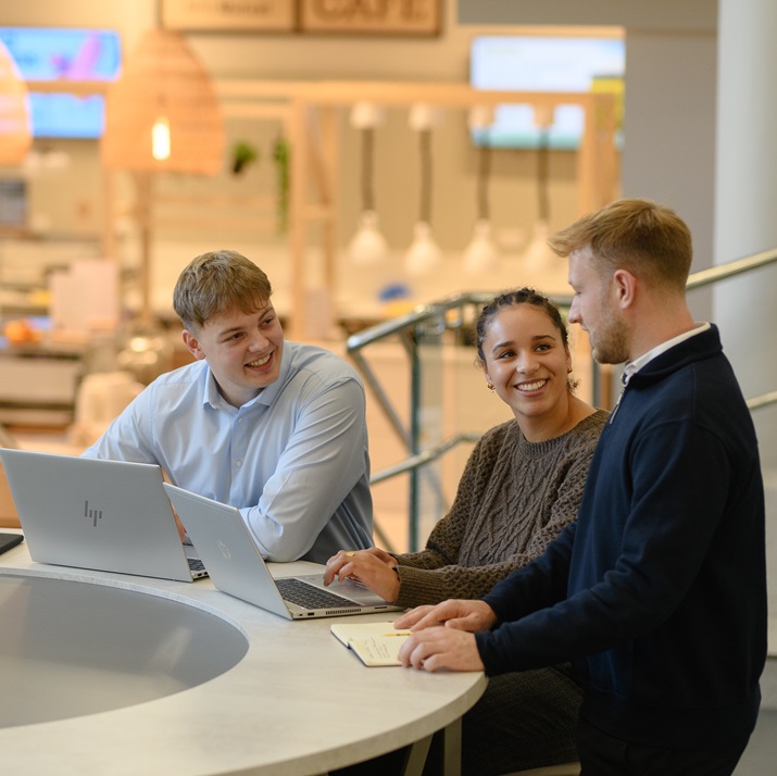 Three NFU Mutual graduates work at a table