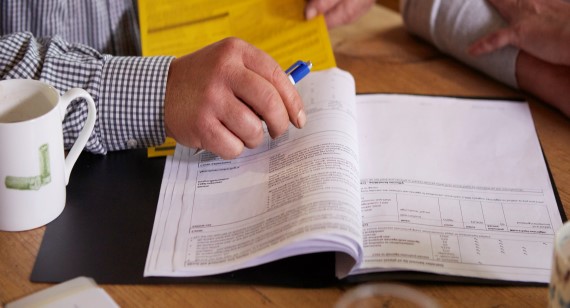 Couple at coffee table signing documents