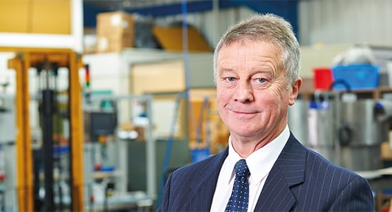 Suited grey haired businessman in warehouse