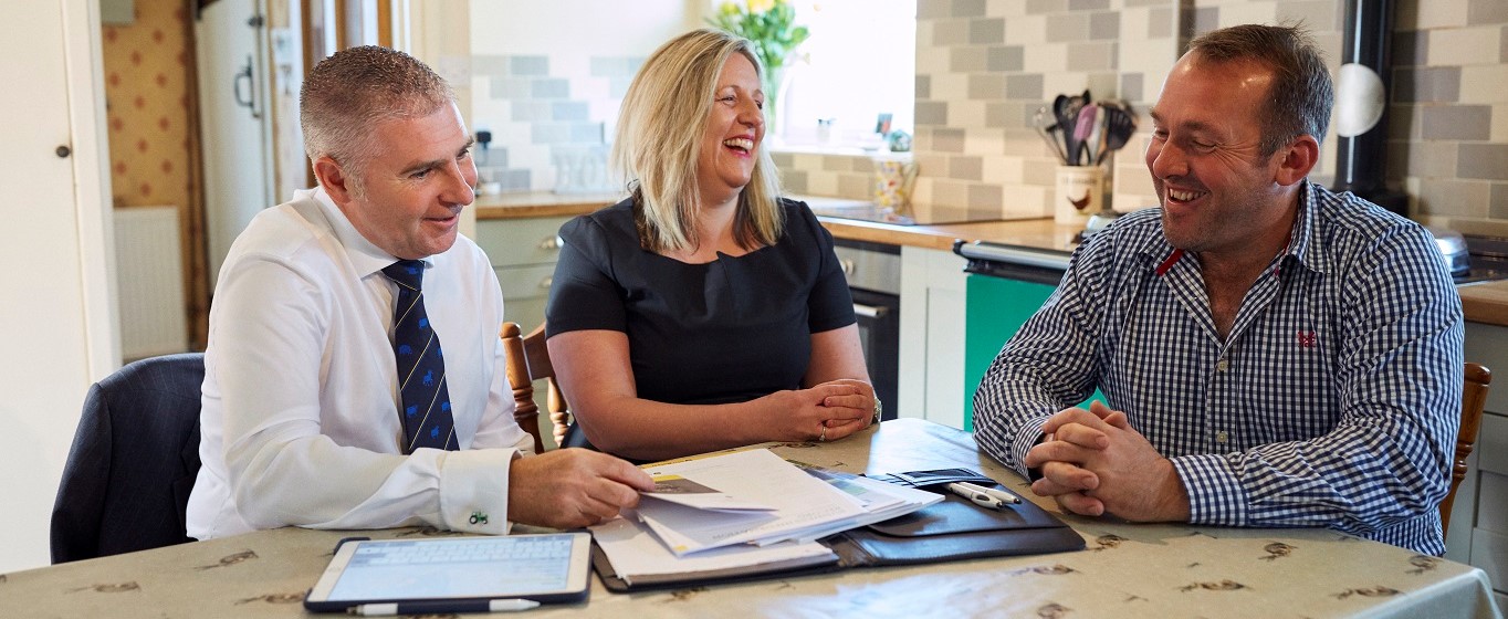 Financial adviser in kitchen with customer laughing