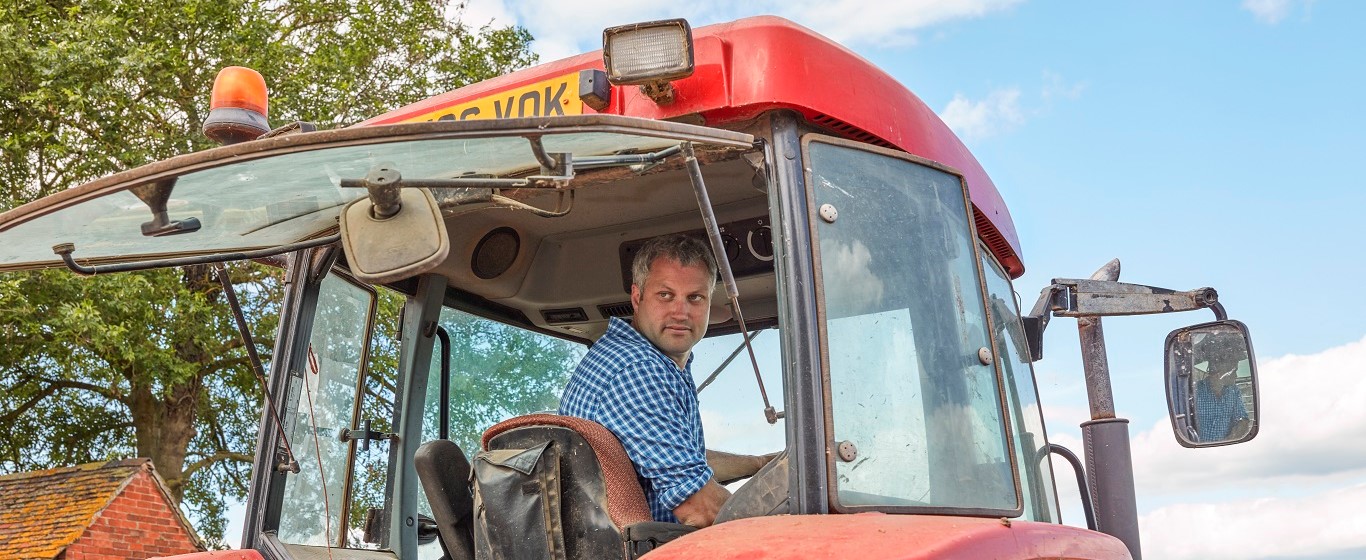 farmer-in-a-red-tractor-looking-behind-him