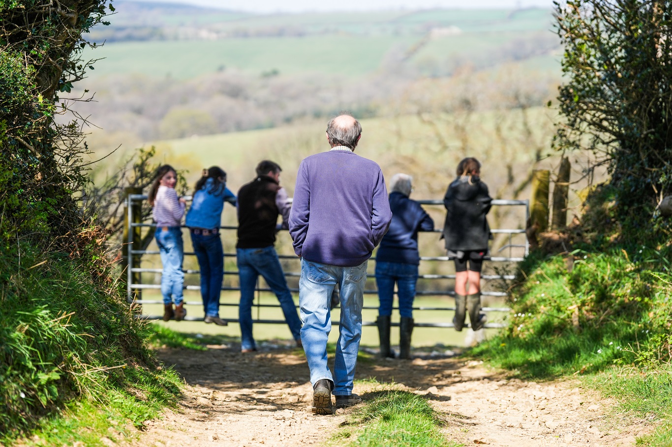 farm family climbing on a gate