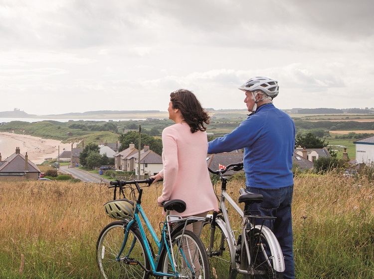 Couple on bikes by coast