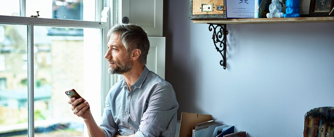 Man on mobile phone looking out of window