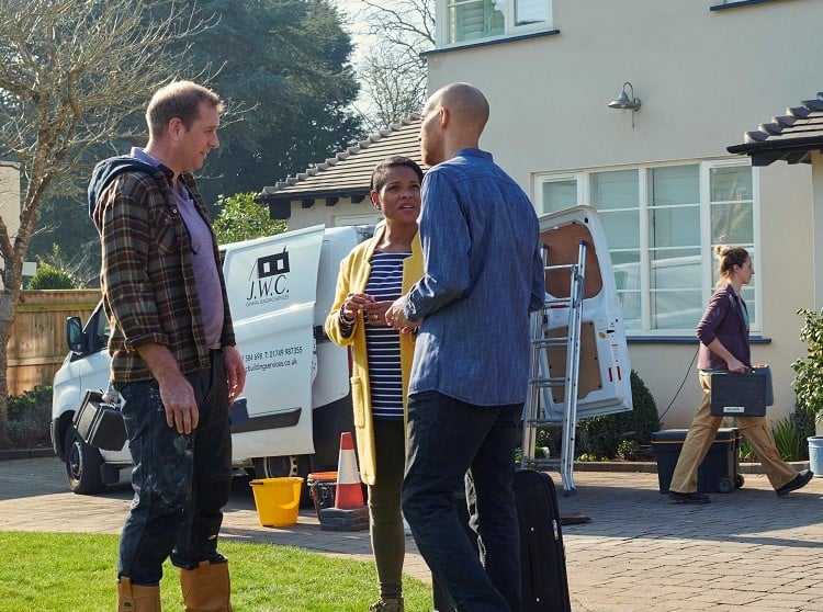 Tradesman and couple outside home