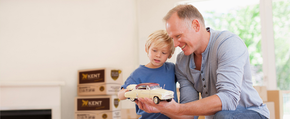 Father showing son toy car during house move