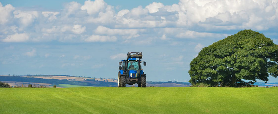 Blue tractor travelling along field