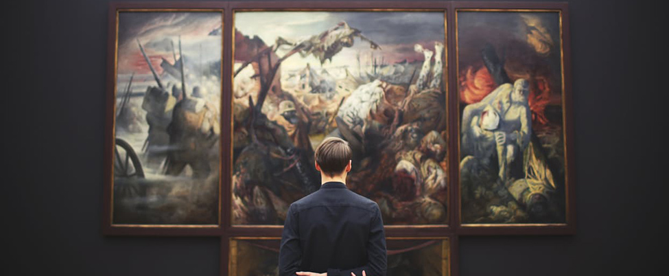 Man stood looking at paintings