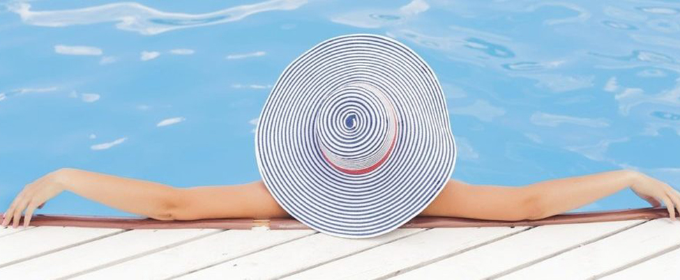 Woman with stripy hat, relaxing in pool