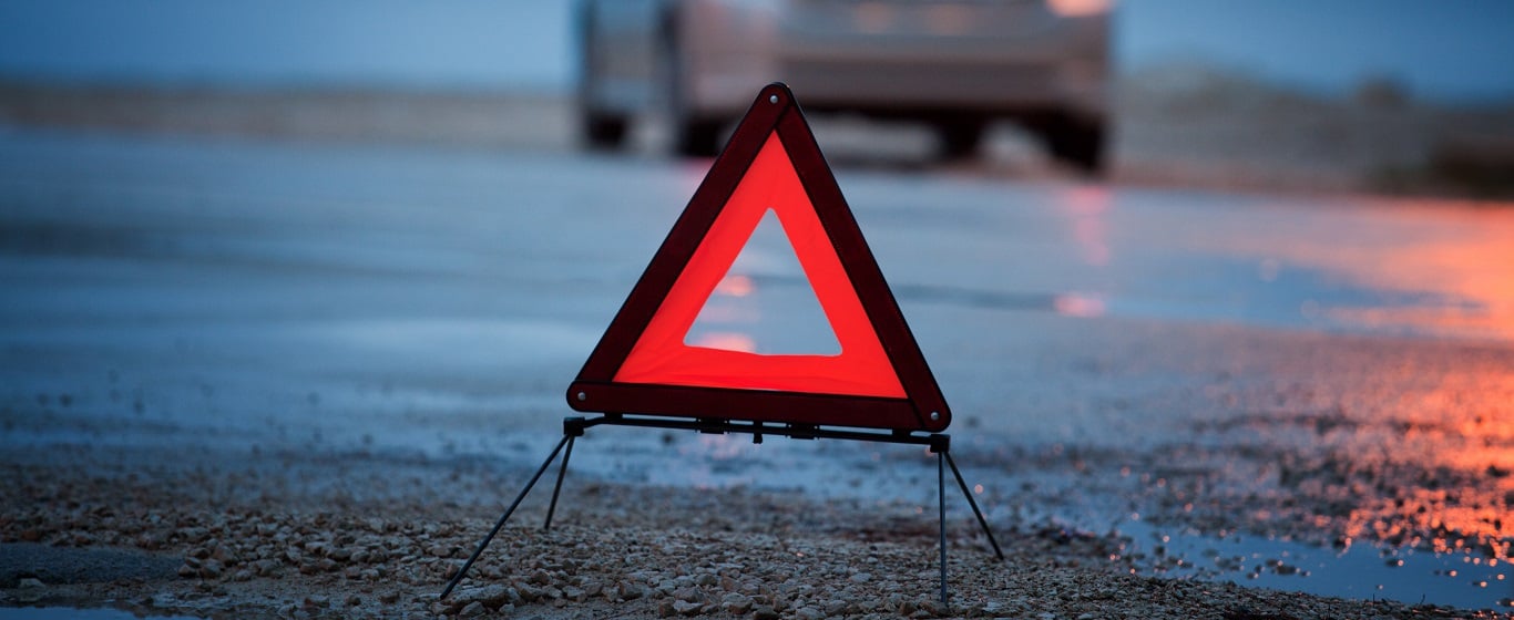 Red warning triangle placed away from silver hatchback