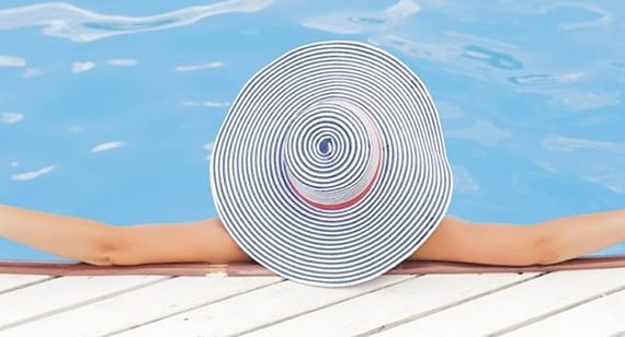 Woman with stripey hat relaxing in pool